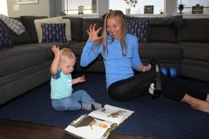 Neely rolls out tired muscles while reading with her son, Athens.