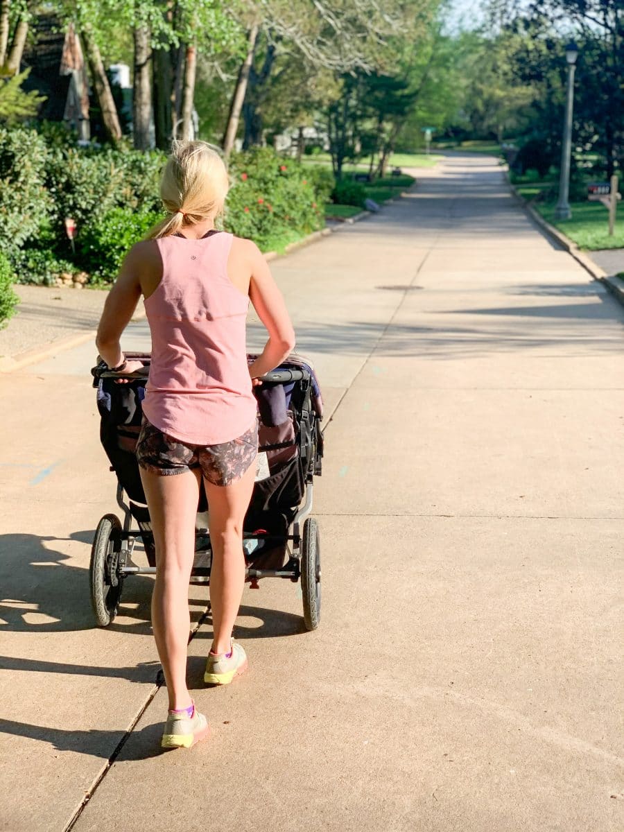 Woman walking with a running stroller.