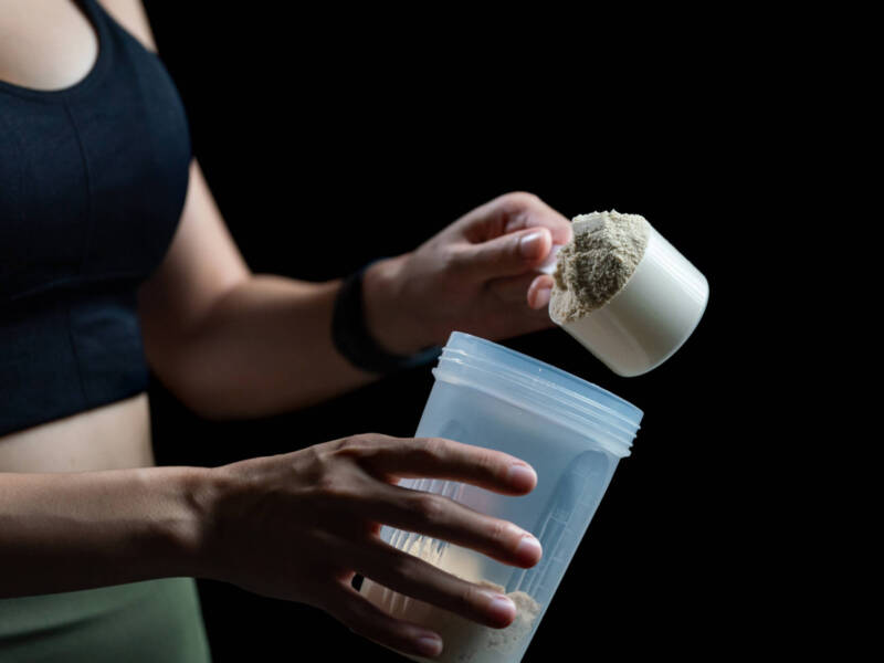 woman adding creatine to shake