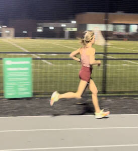 whitney running on a track at night