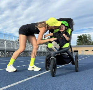 Neely Gracey kisses son Rome after setting the world record in the stroller mile. 