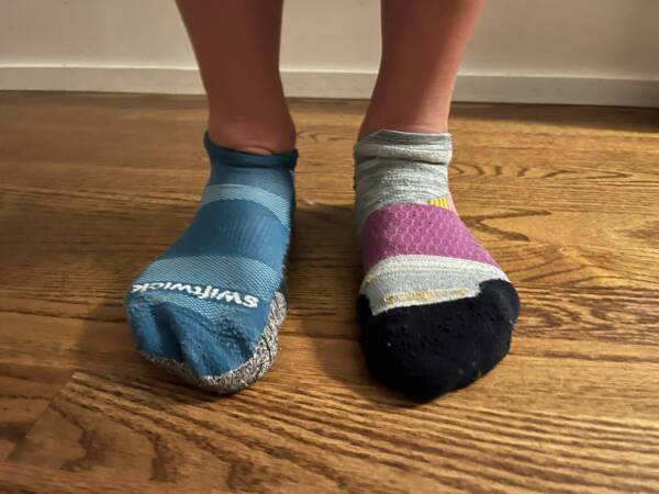 best running socks for runners standing in two different pairs