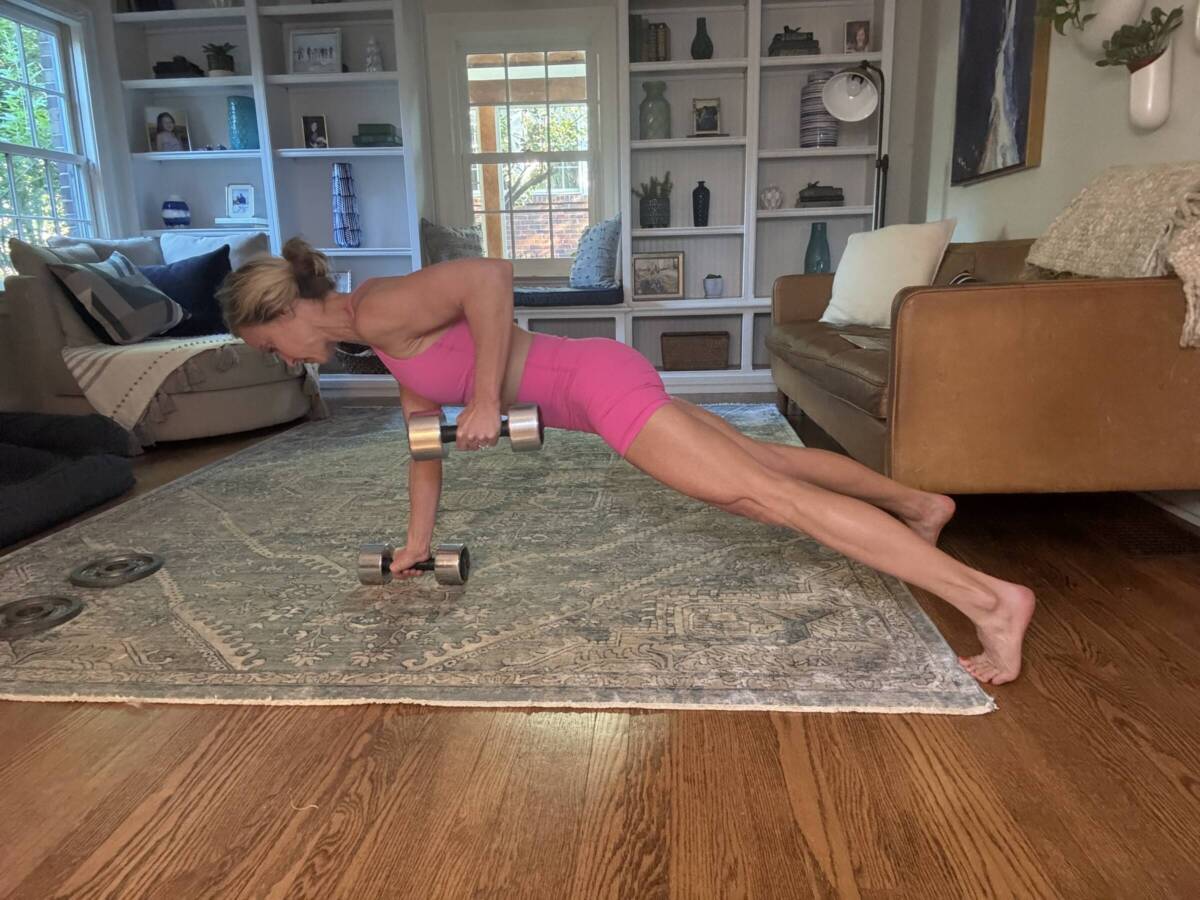 Whitney Heins doing a plank with weights wearing pink